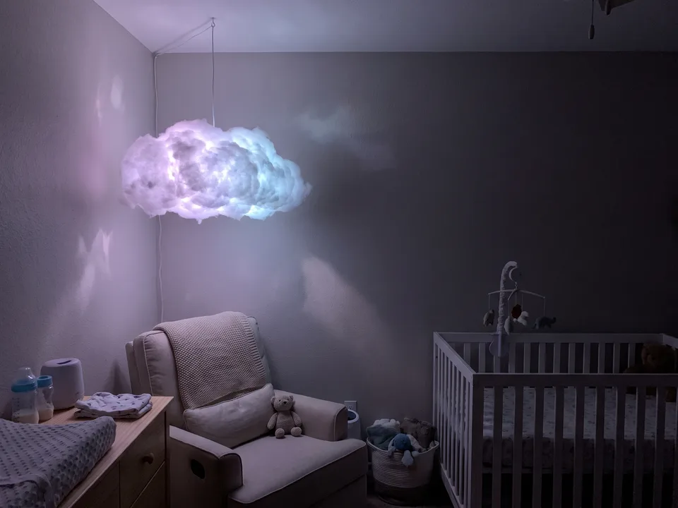 Foto de ejemplo: nube colgante encendida en el rincón de un cuarto de bebé, lejos de la cuna