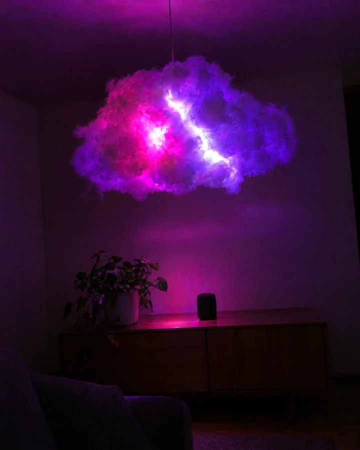 Nube colgante con destello magenta y un rayo blanco en un living a oscuras